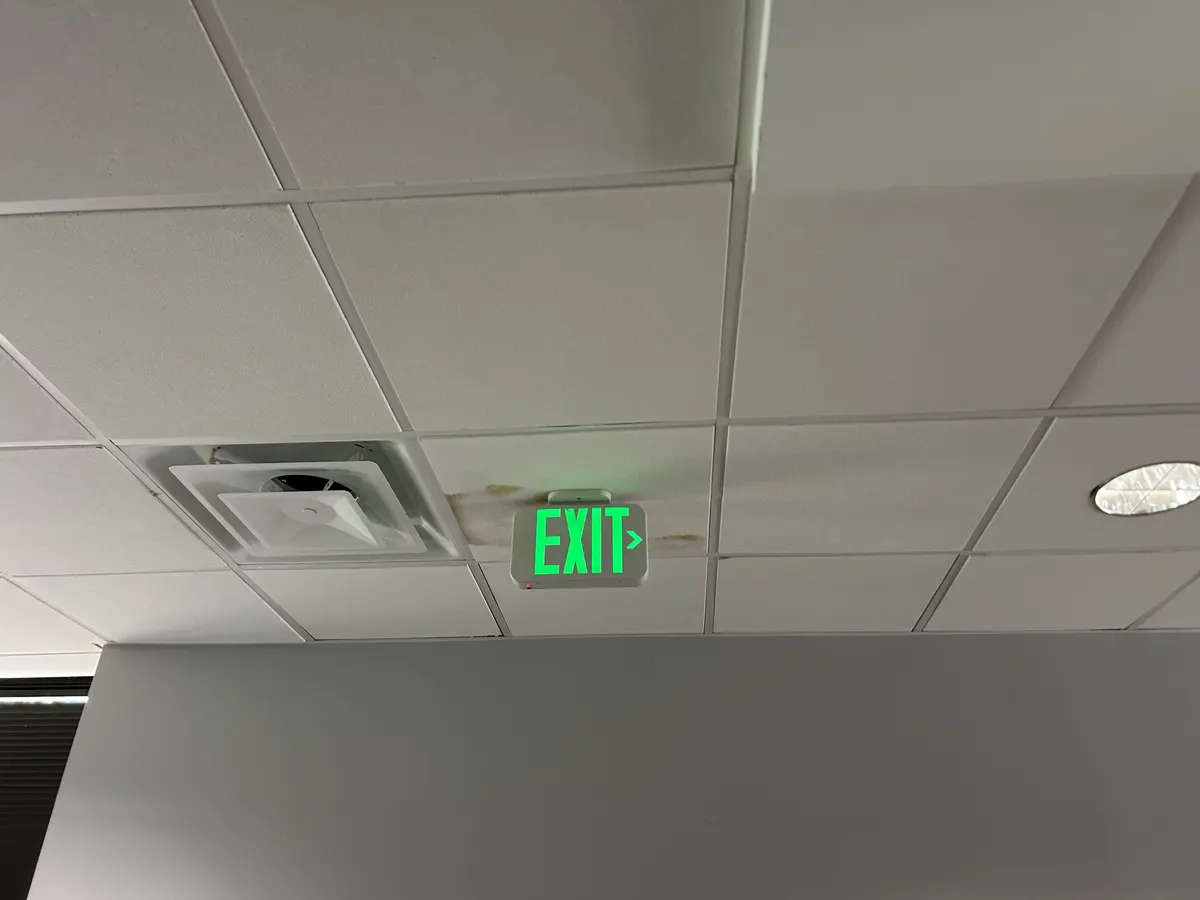 Water-stained and missing ceiling tiles replaced after a roof leak, after