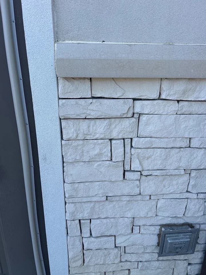Fallen brick at a side door, back in place, after
