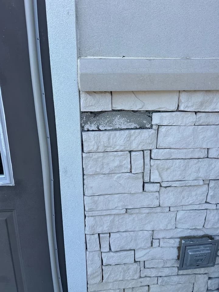 Fallen brick at a side door, back in place, before