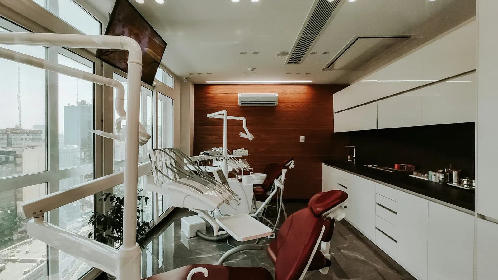 Dental operatory with patient chairs, cabinetry and a sink along the wall