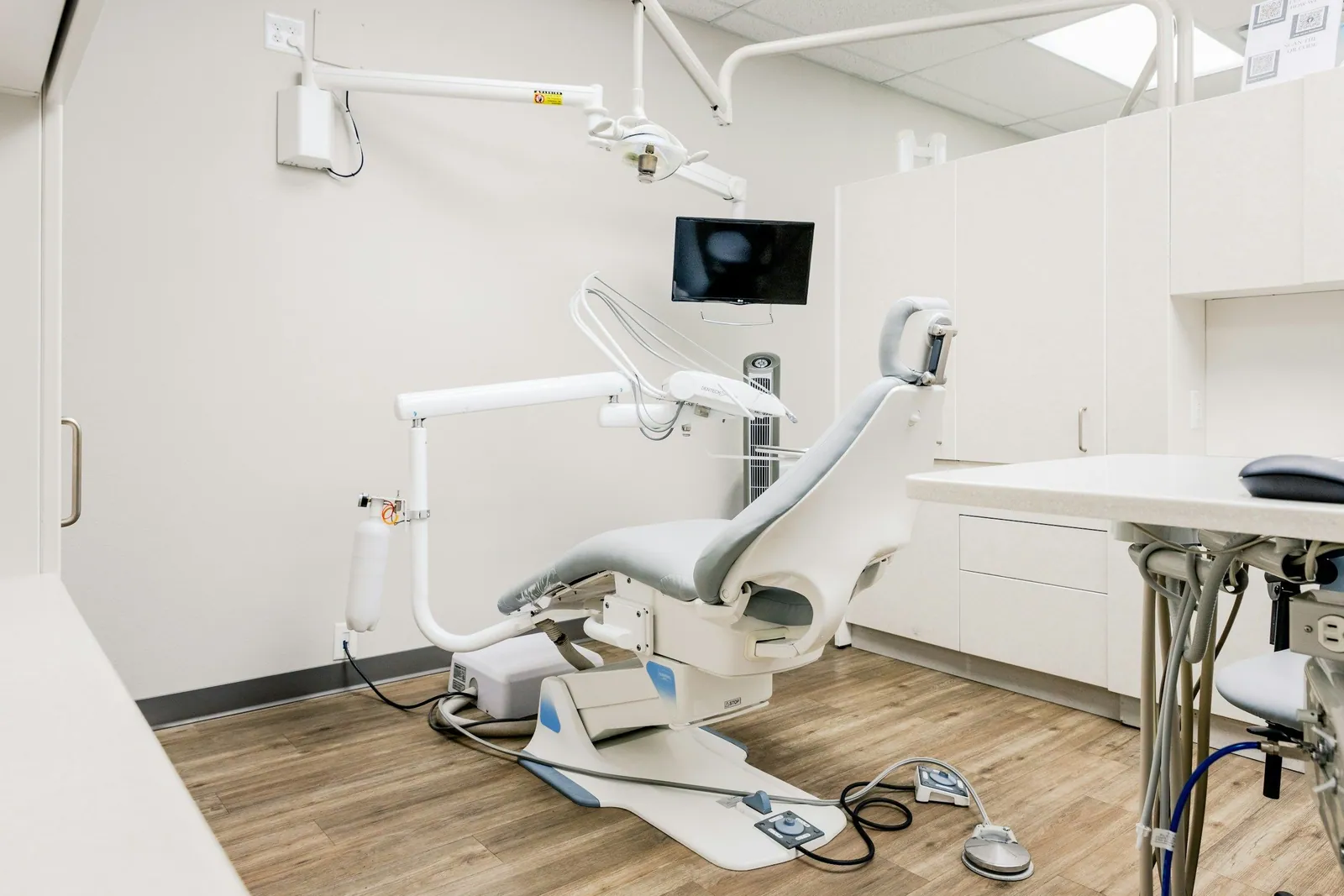 Dental operatory with a patient chair, delivery unit, and cabinetry