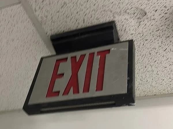 Exit sign mounted at a stairwell ceiling